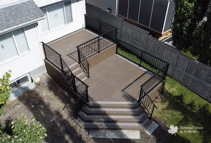 Rocky Harbor composite deck with wide stairs and integrated railing by NFD.